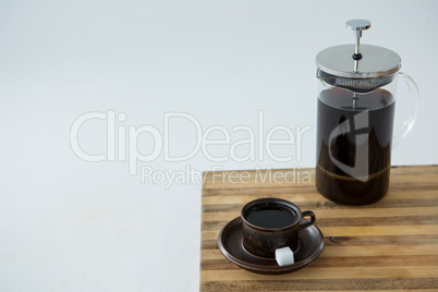 Cafetiere and a cup of black coffee on table