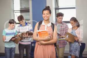 Schoolgirl holding notebook in classroom