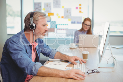 Male graphic designer working while listening music