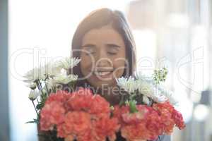 Smiling woman holding a bouquet with eyes closed