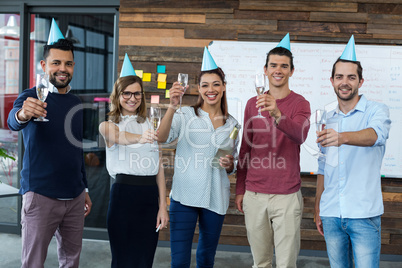 Businesspeople showing glasses of champagne in office