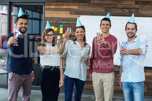 Businesspeople showing glasses of champagne in office