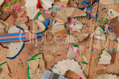 Close-up of sharpener and colored pencil with shavings