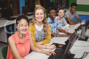 Portrait of smiling students studying in computer classroom
