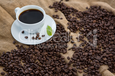 Black coffee, coffee beans and leaf on sack