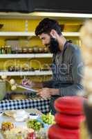 Salesman writing on clipboard at counter