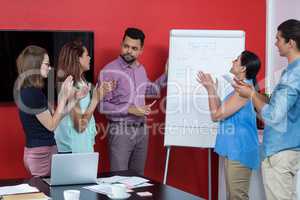 Business executives discussing over flip chart during meeting