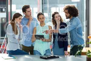 Business team discussing over digital tablet in meeting