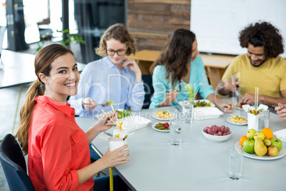 Smiling business executive having meal in office