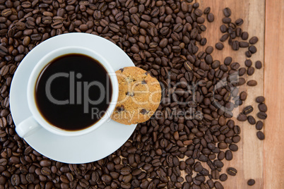 Coffee cup with cookie and coffee beans