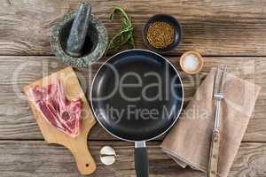 Sirloin steak and ingredients against wooden background