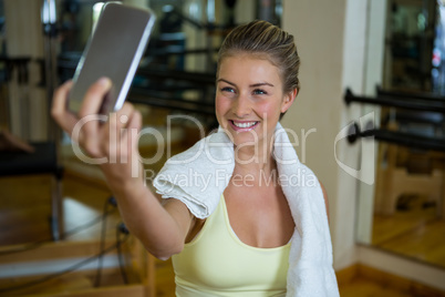 Beautiful fit woman taking selfie on mobile phone after workout