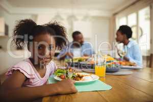 Portrait of girl having meal on dining table