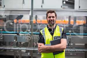 Portrait of smiling factory worker standing with a digital tablet