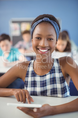 Student holding digital tablet in classroom