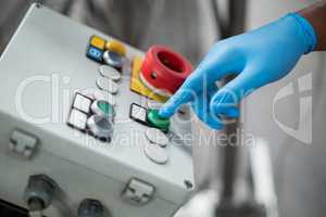 Factory engineer pressing button in bottle factory