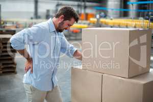 Tensed male worker standing with back pain