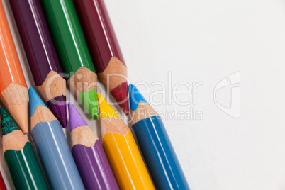 Colored pencils arranged in interlock pattern on white background