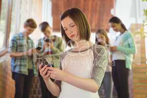 Schoolgirl using mobile phone in corridor