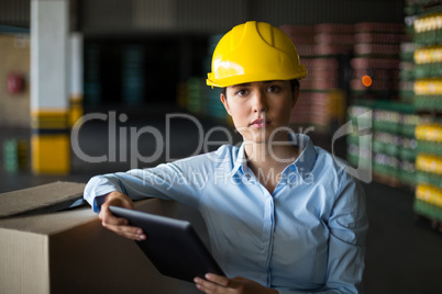 Female factory worker standing with digital tablet in factory