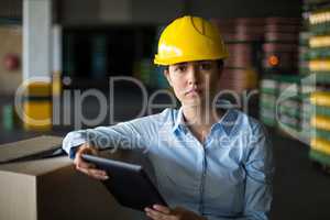 Female factory worker standing with digital tablet in factory