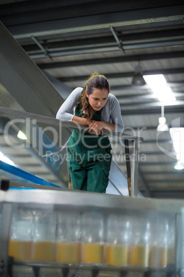 Female factory worker inspecting production line