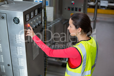 Female factory worker operating machine