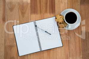 Open diary with pen and black coffee