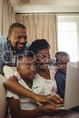 Parents and kids using laptop in living room Parents and kids using laptop in living room