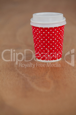Disposable coffee cup on wooden background