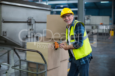Portrait of factory worker loading cardboard boxes