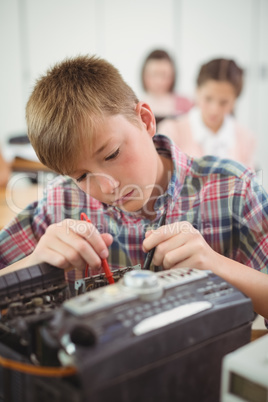 Schoolboy repairing a printer in the classroom