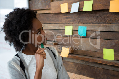 Female graphic designer pointing at sticky notes