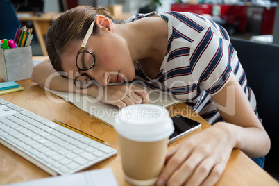 Overworked graphic designer sleeping on his desk