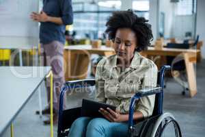 Disabled business executive in wheelchair using digital tablet
