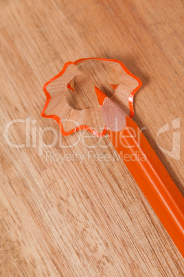 Close-up of orange colored pencil with shavings