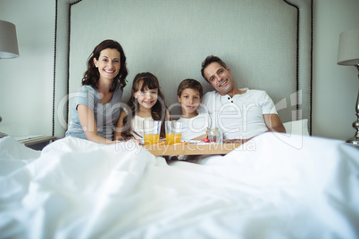 Parents and kids having breakfast in bed