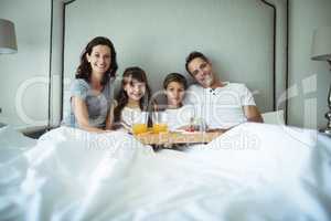 Parents and kids having breakfast in bed