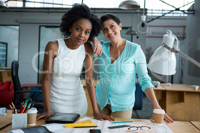 Female graphic designers standing in creative office