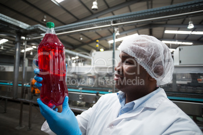 Factory engineer holding a bottle of juice