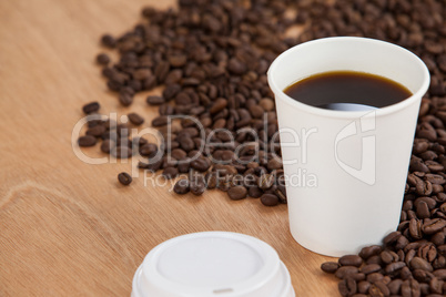 Coffee beans and black coffee in disposable cup
