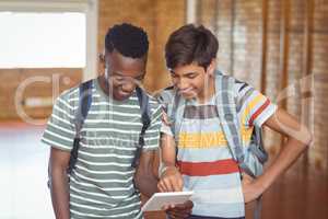 Happy schoolboys using digital tablet in campus