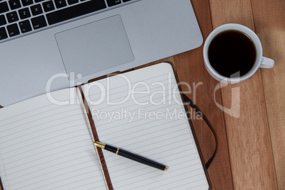 Cup of coffee with laptop, organizer and pen