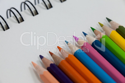 Close-up of colored pencils and notebook