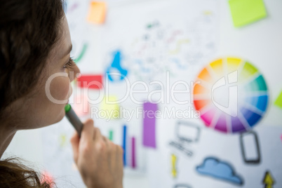 Thoughtful woman looking at adhesive notes