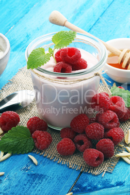 Beautiful appetizer pink raspberries fruit smoothie or milk shake in glass jar with berries background, top view. Yogurt cocktail. Close up. Natural detox. Liquid ice cream.