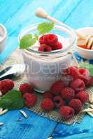 Beautiful appetizer pink raspberries fruit smoothie or milk shake in glass jar with berries background, top view. Yogurt cocktail. Close up. Natural detox. Liquid ice cream.