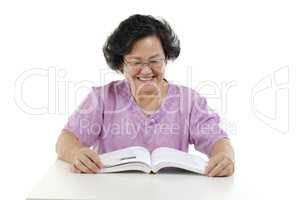 Happy Senior adult woman reading book