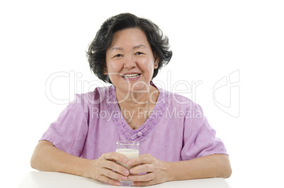 Senior adult woman drinking milk