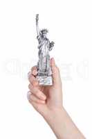 Hand holding a Statue of Liberty souvenir toy